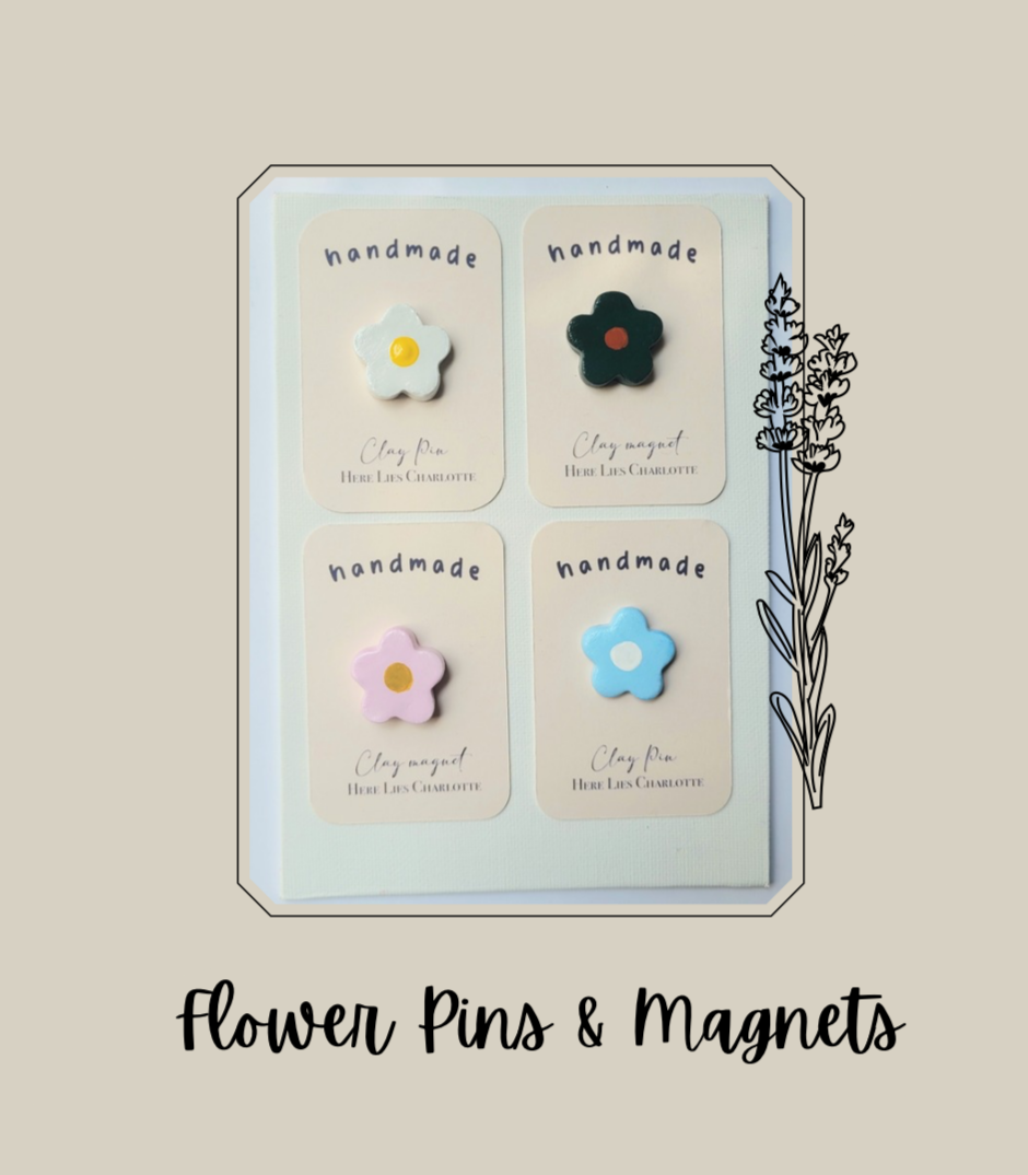 Set of handmade flower pins and magnets in a display case on a beige background.