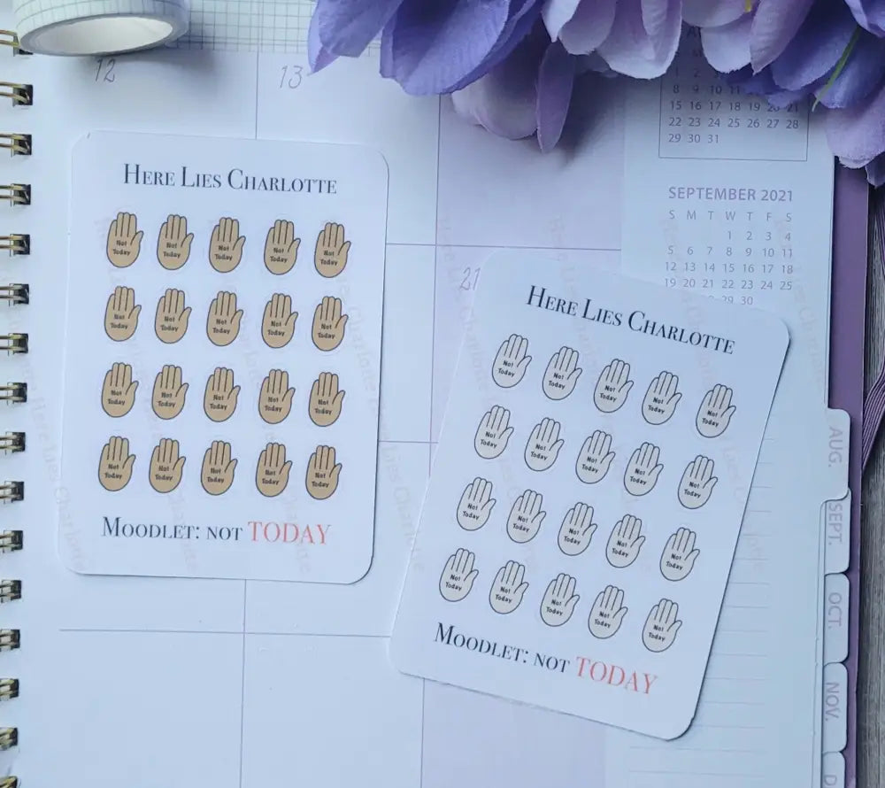 Planner stickers with hand designs and text on a planner page.